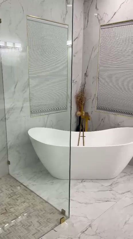 Finished bathroom with marble walls and freestanding tub